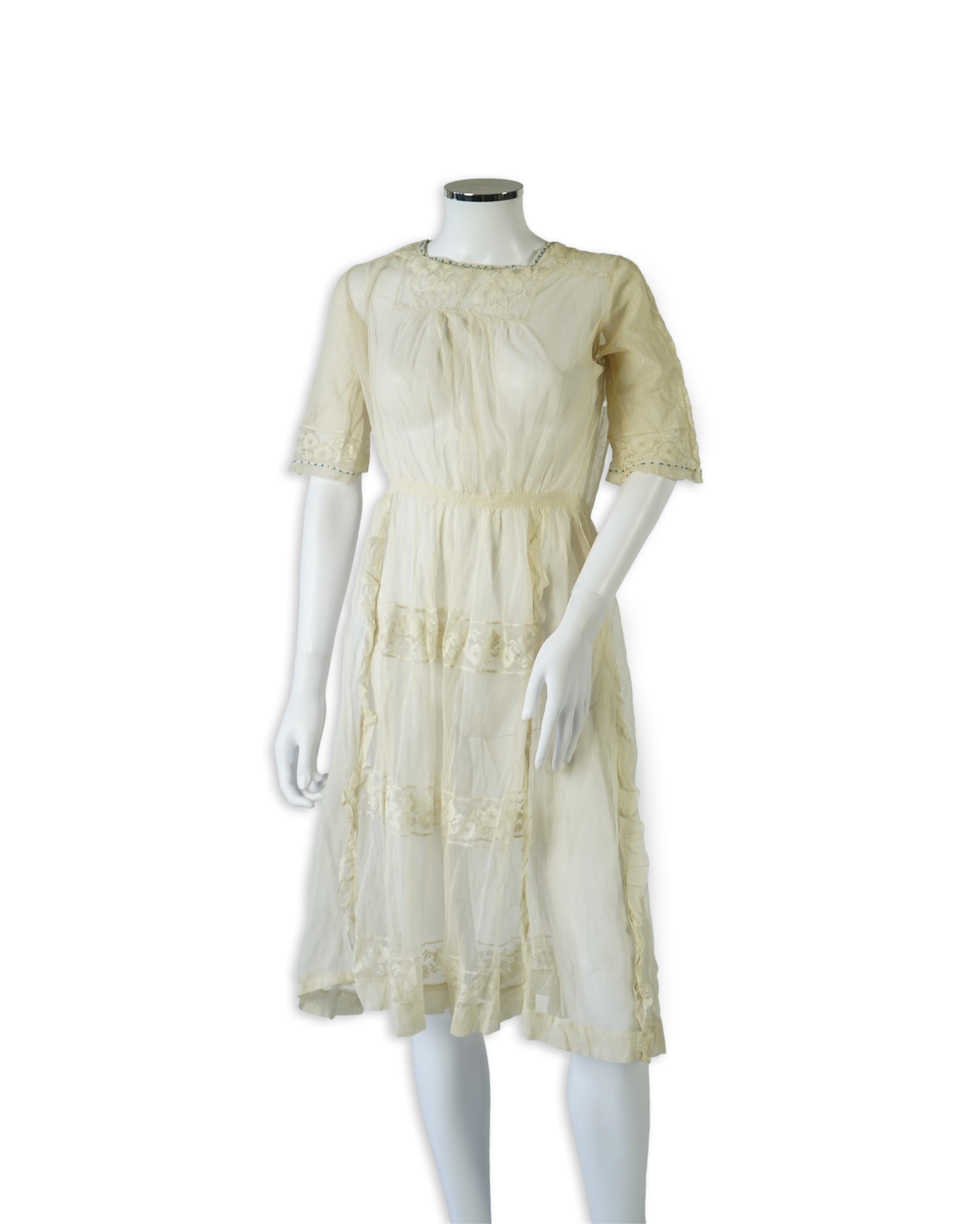 An early 20’s cream net ladies summer dress and net petticoat, designed with a lace inset front skirt, yolk and sleeves.103cm long. Condition - both need re-laundering and some seams tidying.